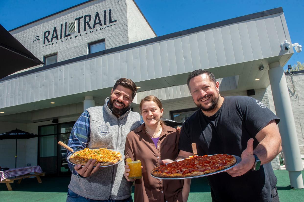 From left, Rail Trail Flatbread Co. partners Michael Kasseris, Vanessa Gilchrist and Anastasios Vitsas on their patio in Milford, April 25, 2024. The restaurant is gearing up for its first outdoor dining season in Milford.