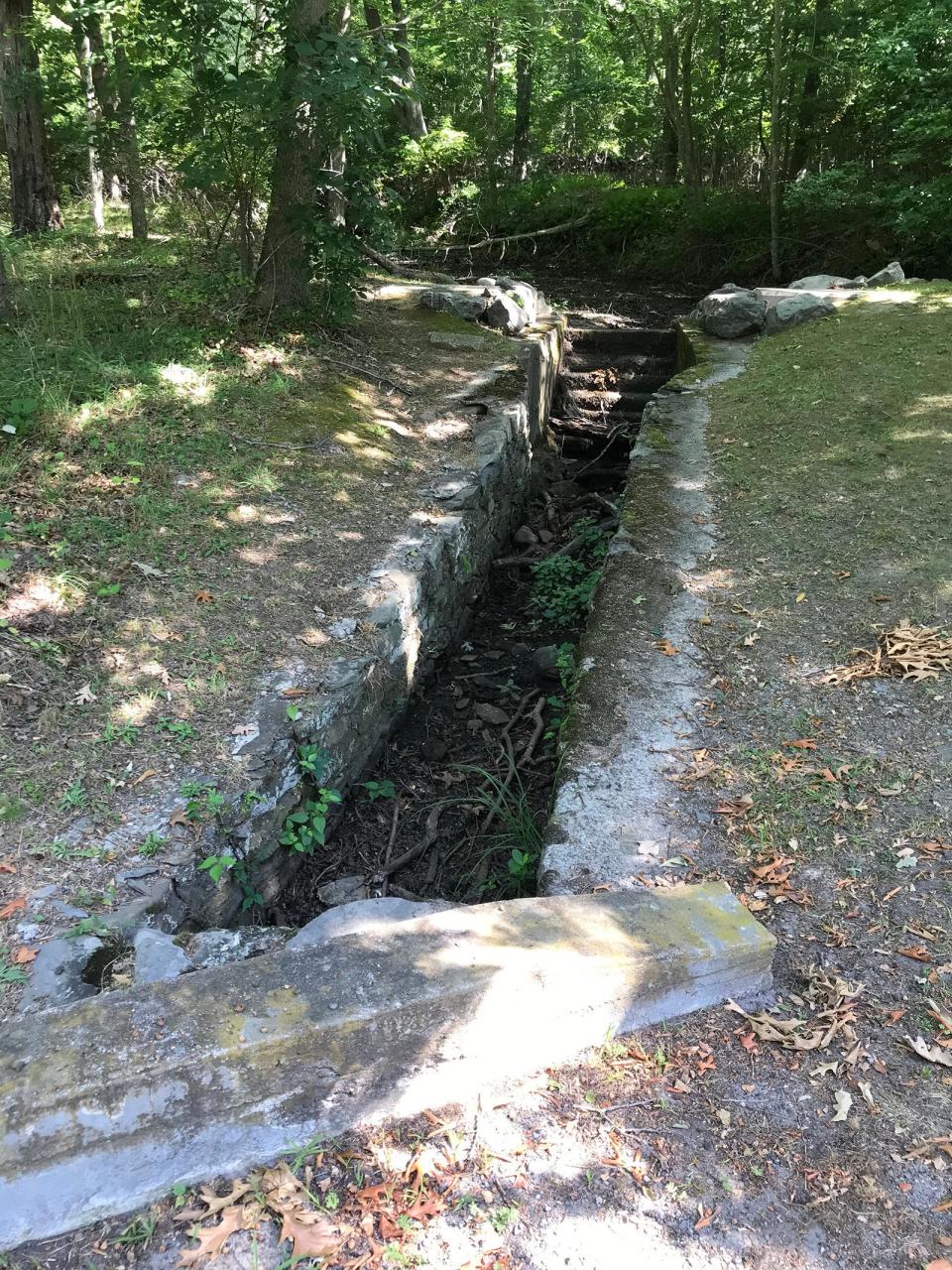Stone-lined channels built by the Works Progress Administration funnel runoff from the hillside to Mount Hope Bay.