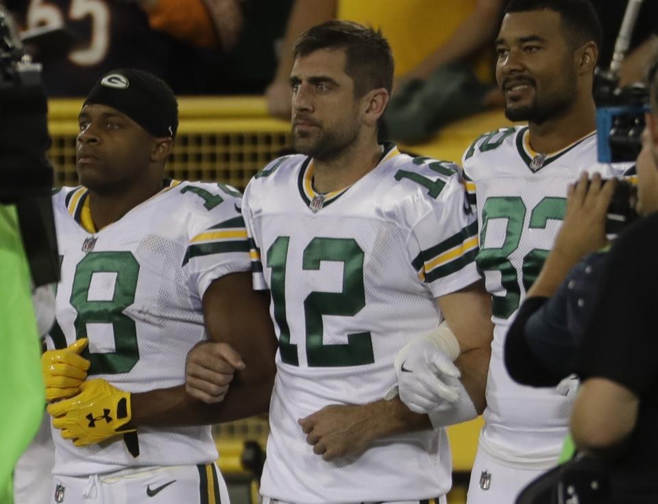 Green Bay Packers' Aaron Rodgers links arms with Richard Rodgers and Randall Cobb during the national anthem on Thursday night. (AP)