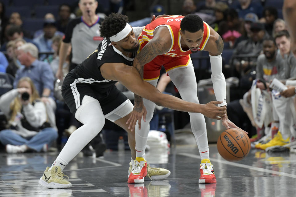 Memphis Grizzlies guard Jordan Goodwin, left, defends against Atlanta Hawks guard Dejounte Murray during the first half of an NBA basketball game Friday, March 8, 2024, in Memphis, Tenn. (AP Photo/Brandon Dill)