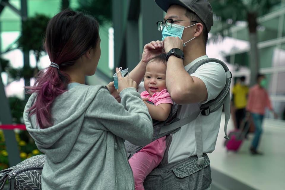 A family adjust their masks at the Kuala Lumpur International Airport 2 in Malaysia. Thailand is at great risk for spreading the virus because of the influx of travelers from mainland China. Thailand has confirmed one of the first human to human transmissions of the coronavirus outside of China.