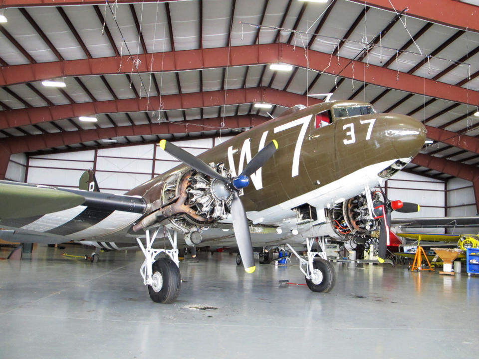 This photo taken March 6, 2014, shows a World War II-era Douglas C-47, housed at the National Warplane Museum in Geneseo, N.Y. At the invitation of the French government, the airplane will return to France in June to participate in celebrations marking the 70th anniversary of the D-Day invasion of Normandy. The airplane, known as Whiskey 7 because of its markings, is one of the original troop carriers that dropped paratroopers in advance of the amphibious invasion. In June it will recreate its role and drop paratroopers over the original drop zone in Sainte-Mere-Eglise. (AP Photo/Carolyn Thompson)