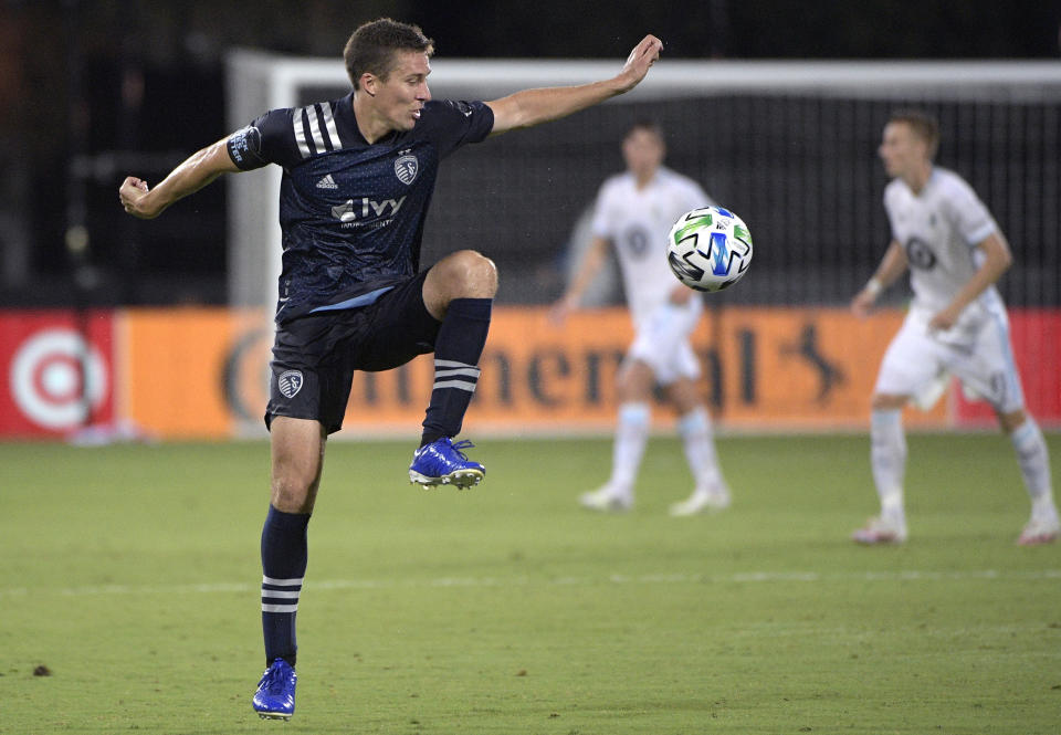 Sporting Kansas City defender Matt Besler, left, controls a pass during the first half of the team's MLS soccer match against Minnesota United, Sunday, July 12, 2020, in Kissimmee, Fla. (AP Photo/Phelan M. Ebenhack)