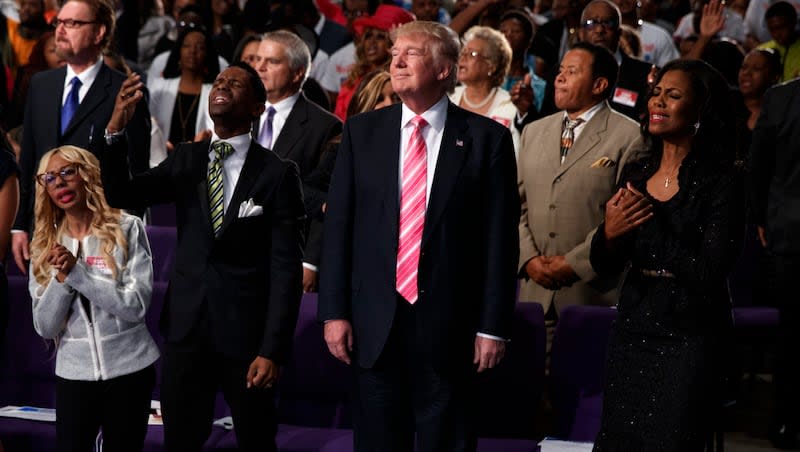 Donald Trump, center, looks on during a church service at Great Faith Ministries, Saturday, Sept. 3, 2016, in Detroit.