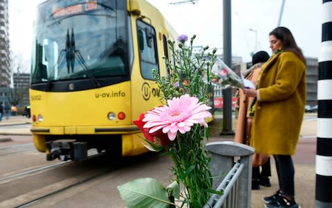 Flowers have been set up in tribute to victims at the site of the shooting in a tram - Credit: JOHN THYS/&nbsp;AFP