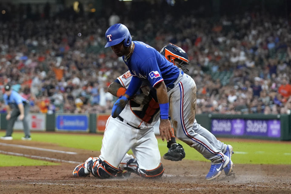 Texas Rangers' Ezequiel Duran, right, is tagged out at home plate by Houston Astros catcher Martin Maldonado during the seventh inning of a baseball game Wednesday, Aug. 10, 2022, in Houston. (AP Photo/David J. Phillip)