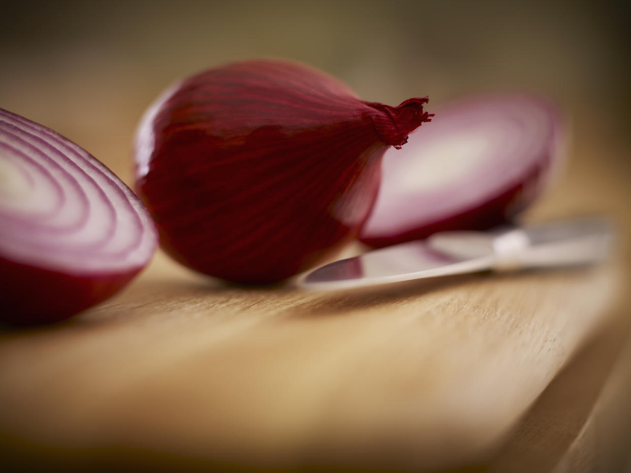 Close up of red onions and knife on cutting board