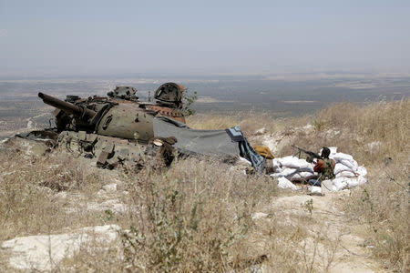 FILE PHOTO: A rebel fighter from the Ahrar al-Sham Islamic Movement takes position on a hill in Jabal al-Arbaeen, which overlooks the northern town of Ariha, one of the last government strongholds in the Idlib province May 26, 2015. REUTERS/Khalil Ashawi/File Photo