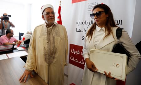 Abdel Fattah Morou, vice-president of the moderate Islamist party Ennahda stands next to his daughter, as he presents his candidacy for the presidential elections, in Tunis