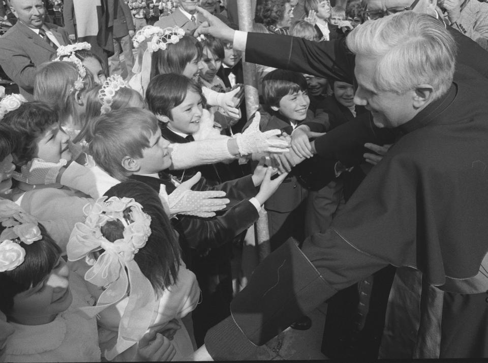 FILE - Joseph Ratzinger, archbishop of Munich and Freising, greets children in front of the Ramersdorfer Marienkirche (church of Mary) after being nominated archbishop on May 23, 1977. Ratzinger went on to become Pope Benedict XVI. Pope Emeritus Benedict XVI, the German theologian who will be remembered as the first pope in 600 years to resign, has died, the Vatican announced Saturday. He was 95. (AP Photo/Dieter Endlicher, File)
