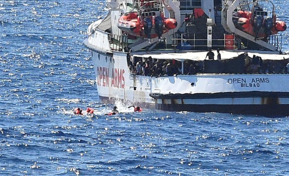 Migrants swim after jumping off the Spanish rescue ship Open Arms. (REUTERS)