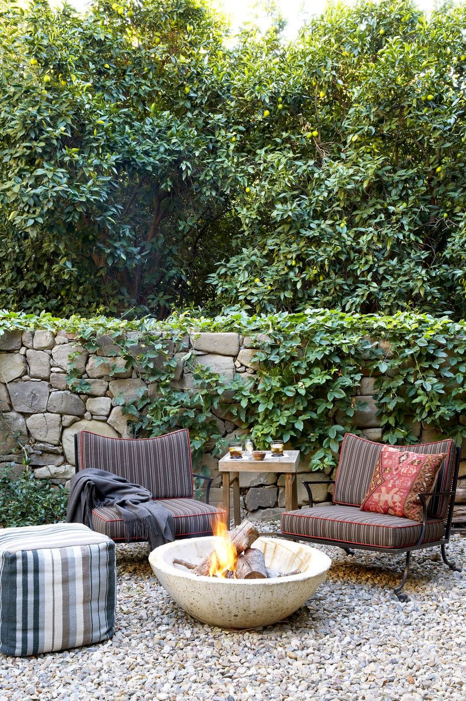 a fire pit with chairs and a table with a fire in it