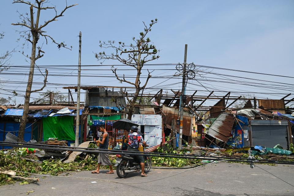 People pass by damaged structures in Sittwe, Myanmar, on Monday. 