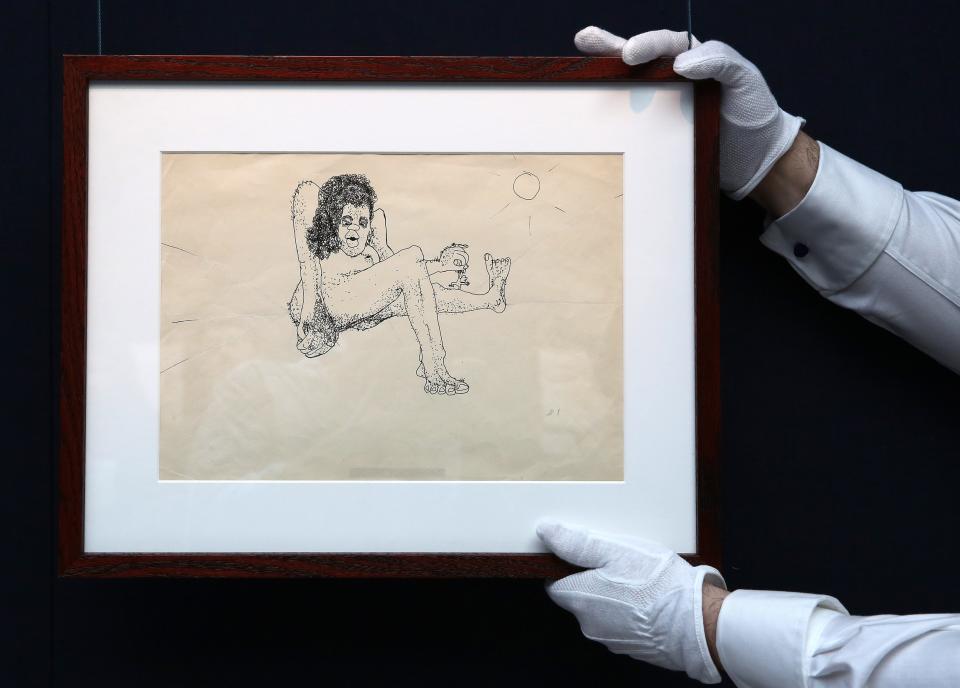 An untitled illustration by John Lennon of a hairy woman holding a minature man by the arm is held by a Sotheby's employee, London March 21, 2014. The illustration, which will be sold in New York in June, is part of a group of letters and drawings entitled John Lennon ' You Might As Well Arsk,' and is estimated to be auctioned for between $12,000 to 15,000 (7,270 to 9,000 pounds). REUTERS/Paul Hackett (BRITAIN - Tags: ENTERTAINMENT SOCIETY)