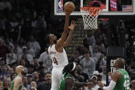 Cleveland Cavaliers forward Evan Mobley (4) shoots between Boston Celtics' Derrick White, left, Jrue Holiday, center, and Al Horford (42) during the second half of Game 3 of an NBA basketball second-round playoff series Saturday, May 11, 2024, in Cleveland. (AP Photo/Sue Ogrocki)