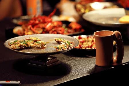 A penis-shaped cup and seafood stand on a table of Ke'er restaurant (Shell in English) in Beijing, China, May 26, 2016. REUTERS/Kim Kyung-Hoon