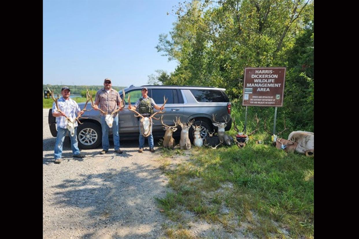 The agents posed with confiscated taxidermy in a wildlife management area near Madisonville, Kentucky.