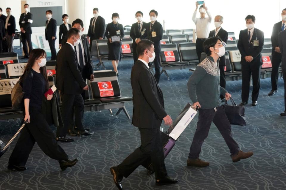 Japan's former Princess Mako, left, the elder daughter of Crown Prince Akishino, and her husband Kei Komuro, right, walk to board a plane to New York (AP)