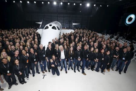 Richard Branson (C) poses after unveiling the new SpaceShipTwo, a six-passenger two-pilot vehicle meant to ferry people into space that replaces a rocket destroyed during a test flight in October 2014, in Mojave, California, United States, February 19, 2016. REUTERS/Lucy Nicholson