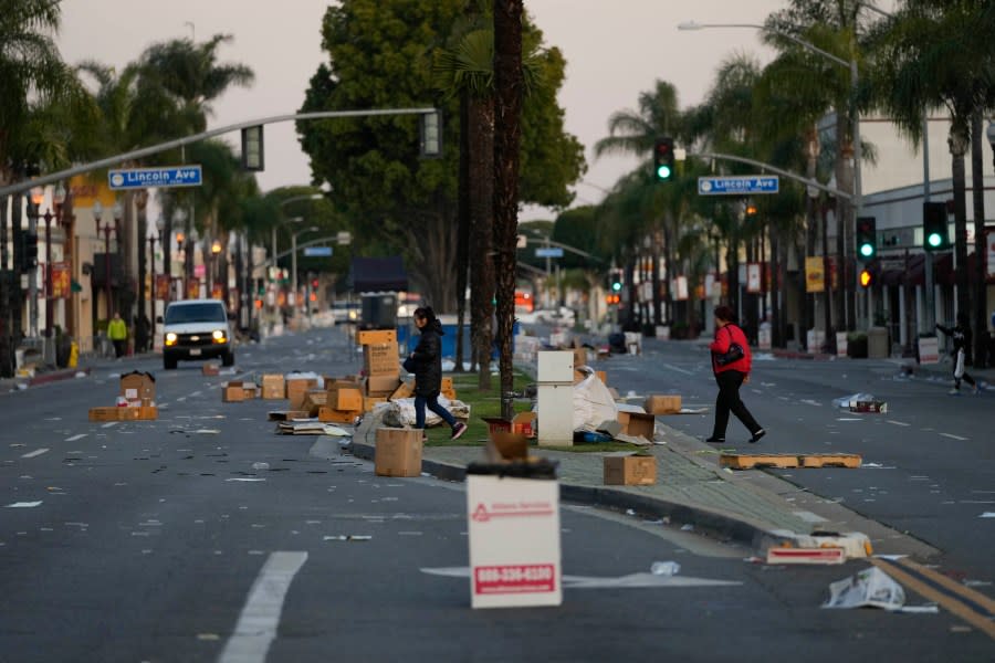 Residents walk across a Lunar New Year festival site after it was canceled due to a mass shooting nearby in Monterey Park, Calif., Sunday, Jan. 22, 2023. A gunman killed multiple people at a ballroom dance studio late Saturday amid Lunar New Years celebrations in the predominantly Asian American community of Monterey Park. (AP Photo/Jae C. Hong)