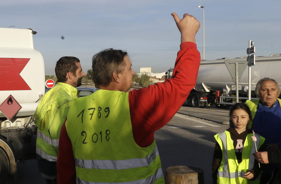 A group of demonstrators wearing their yellow vest, one referring to the 1789 French Revolution, occupy a traffic circle, Wednesday, Dec. 5, 2018 outside La Mede oil refinery, near Martigues, southeastern France. Trade unions and farmers pledged Wednesday to join nationwide protests against President Emmanuel Macron, as concessions by the government failed to stem the momentum of the most violent demonstrations France has seen in decades. (AP Photo/Claude Paris)