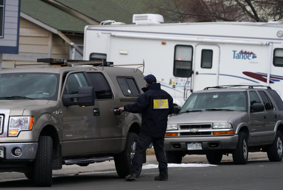 A National Transportation Safety Board investigator exits his vehicle near a home peppered by parts from a plane as it was making an emergency landing at nearby Denver International Airport Saturday, Feb. 20, 2021, in Broomfield, Colo. (AP Photo/David Zalubowski)