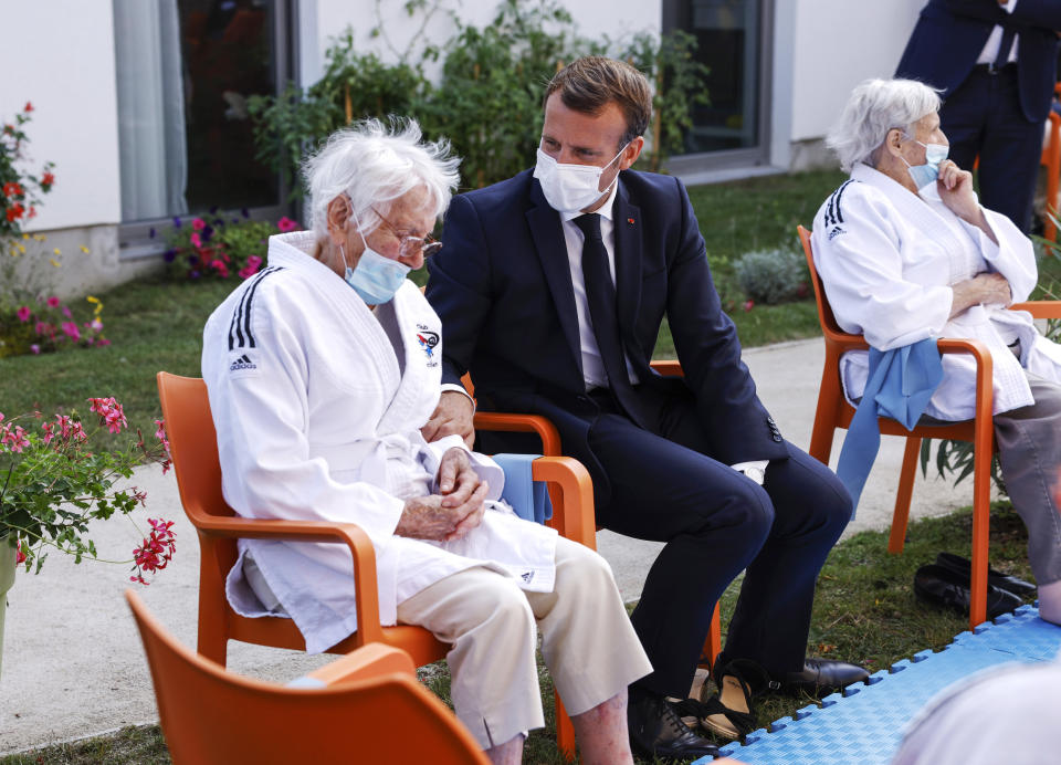 French President Emmanuel Macron, right, talks to a resident at the 'La Bonne Eure' nursing home in Bracieux, central France, Tuesday, Sept. 22, 2020. For the first time in months, virus infections and deaths in French nursing homes are on the rise again. (Yoan Valat/Pool Photo via AP)