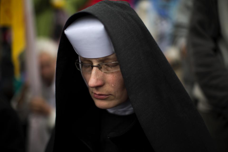 A nun cries as Pope Francis leads a solemn ceremony in St. Peter's Square at the Vatican Sunday, April 27, 2014. Pope Francis has declared his two predecessors John XXIII and John Paul II saints in an unprecedented canonization ceremony made even more historic by the presence of retired Pope Benedict XVI. (AP Photo/Emilio Morenatti)