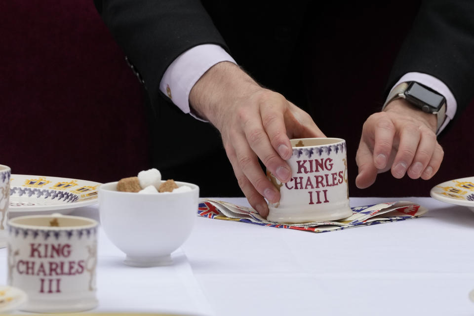 A waiter puts the finishing touches to a place setting for Prime Minister Rishi Sunak's Big Lunch party at Downing Street in London Sunday, May 7, 2023. The Big Lunch is part of the weekend of celebrations for the Coronation of King Charles III. (AP Photo/Frank Augstein, Pool)