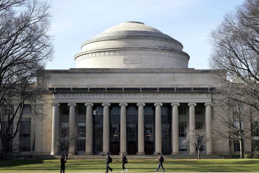 Students walk past the "Great Dome" atop Building 10 on the MIT campus in Cambridge, Mass.