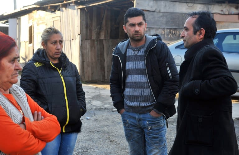 The first Bosnian Roma to head a municipal council, Redzo Seferovic (R) gesturing and speaking with other Bosnian Roma people, on the outskirts of Zavidovici, northern Bosnia