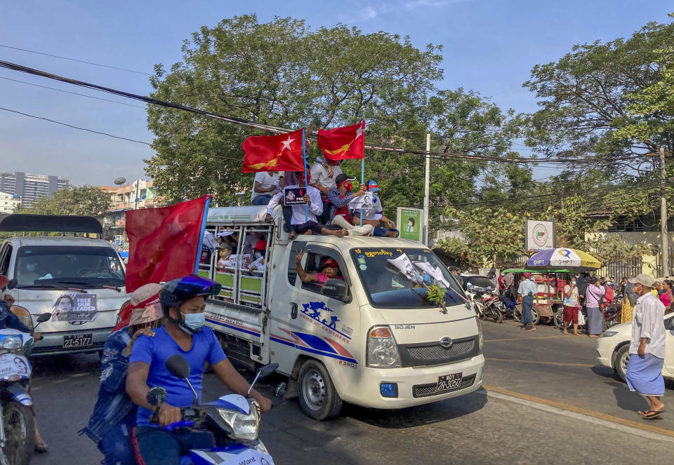 Demonstrators wave flags of National League for Democracy party against the military coup in Yangon, Myanmar Thursday, Feb. 12, 2021. Large crowds demonstrating against the military takeover in Myanmar again defied a ban on protests, even after security forces ratcheted up the use of force against them. (AP Photo)