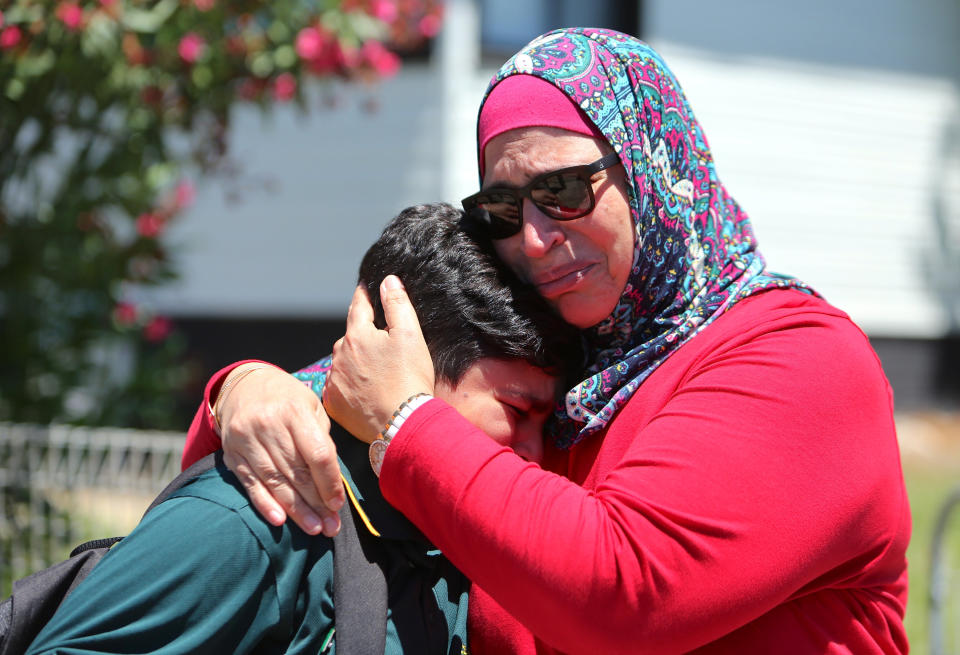 A woman hugs her son near the school after the crash (Picture: Reuters)