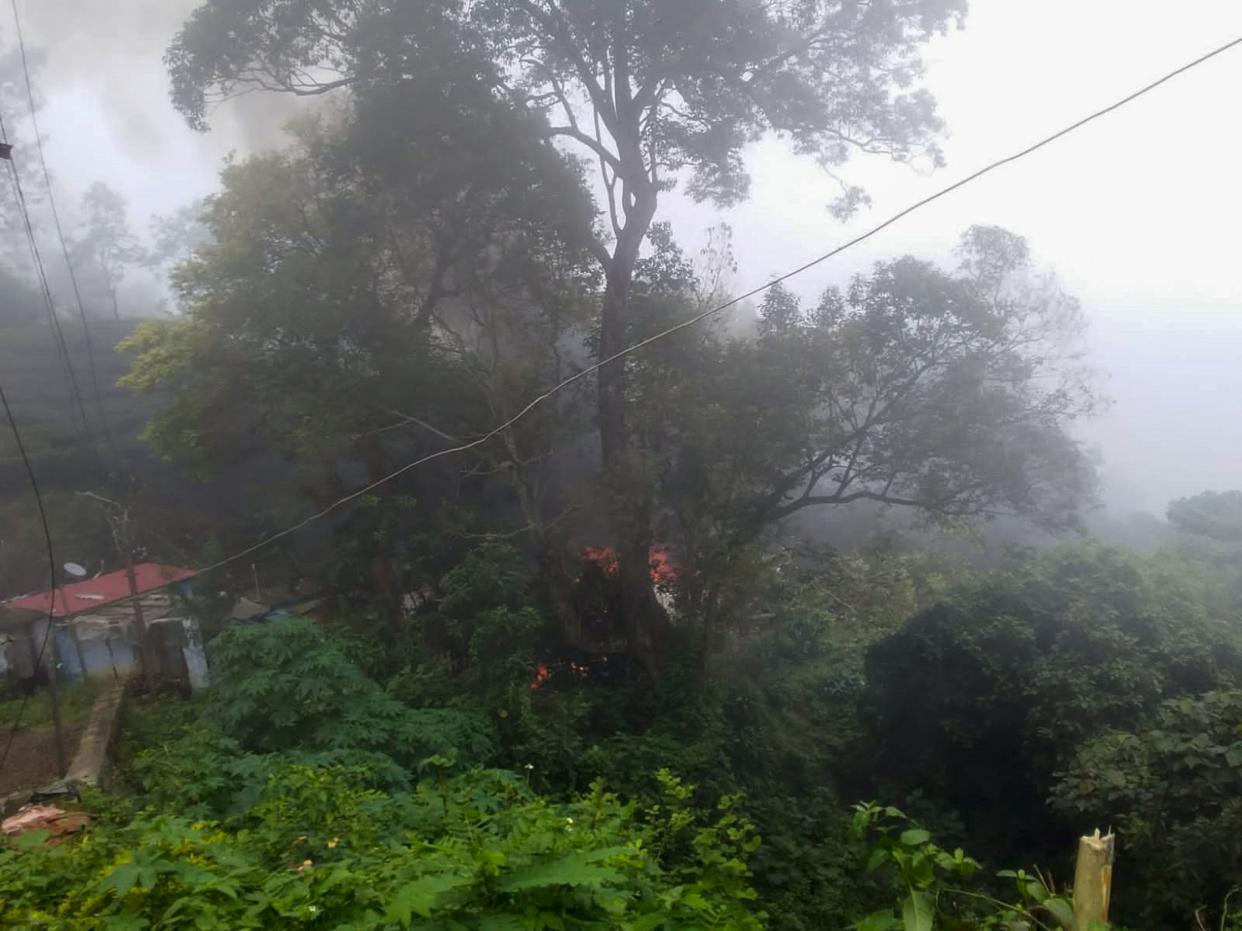 Smoke rises from fire after an army helicopter carrying India's Chief of Defense Staff Bipin Rawat crashed near Coonoor, Tamil Nadu state,  India, on Wednesday.