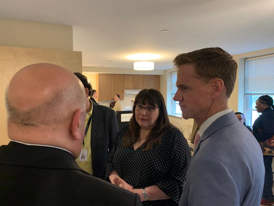 Crossroads RI President Michelle Wilcox, center, talks during a ribbon cutting for four apartments on Thursday.