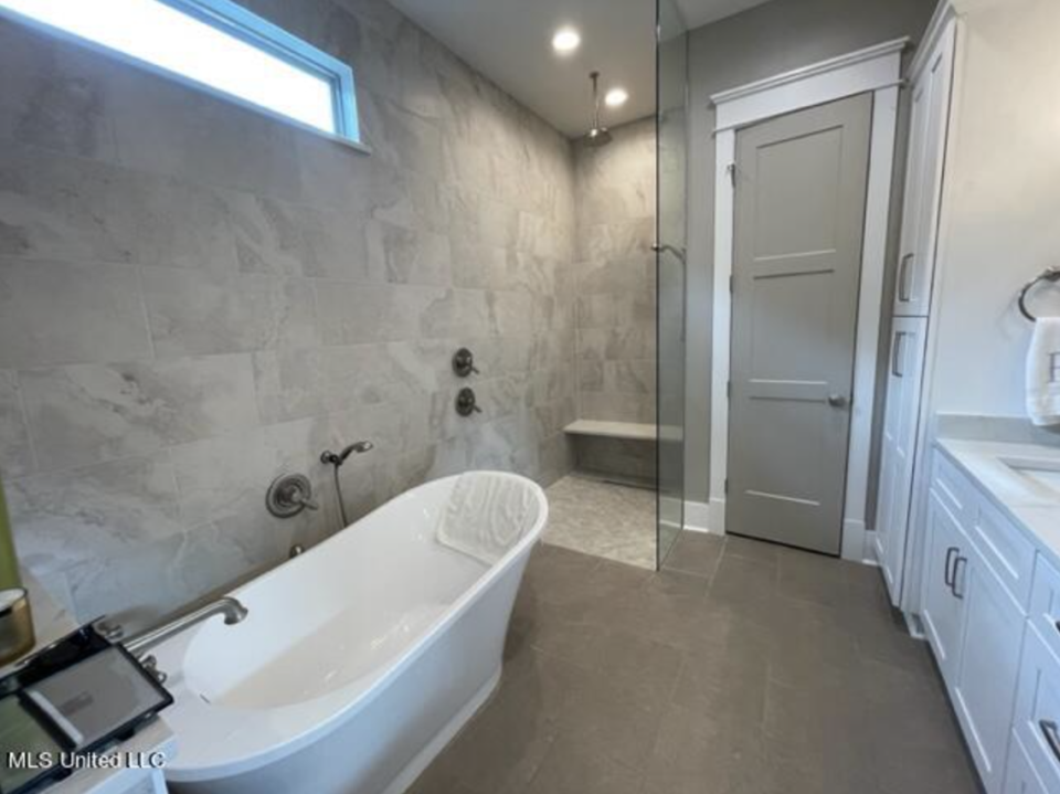 A double vanity, soaking tub and walk-in shower can be found in this bathroom in a three-bedroom, two bath home for sale in The Courtyards at Dunbar in Bay St. Louis.