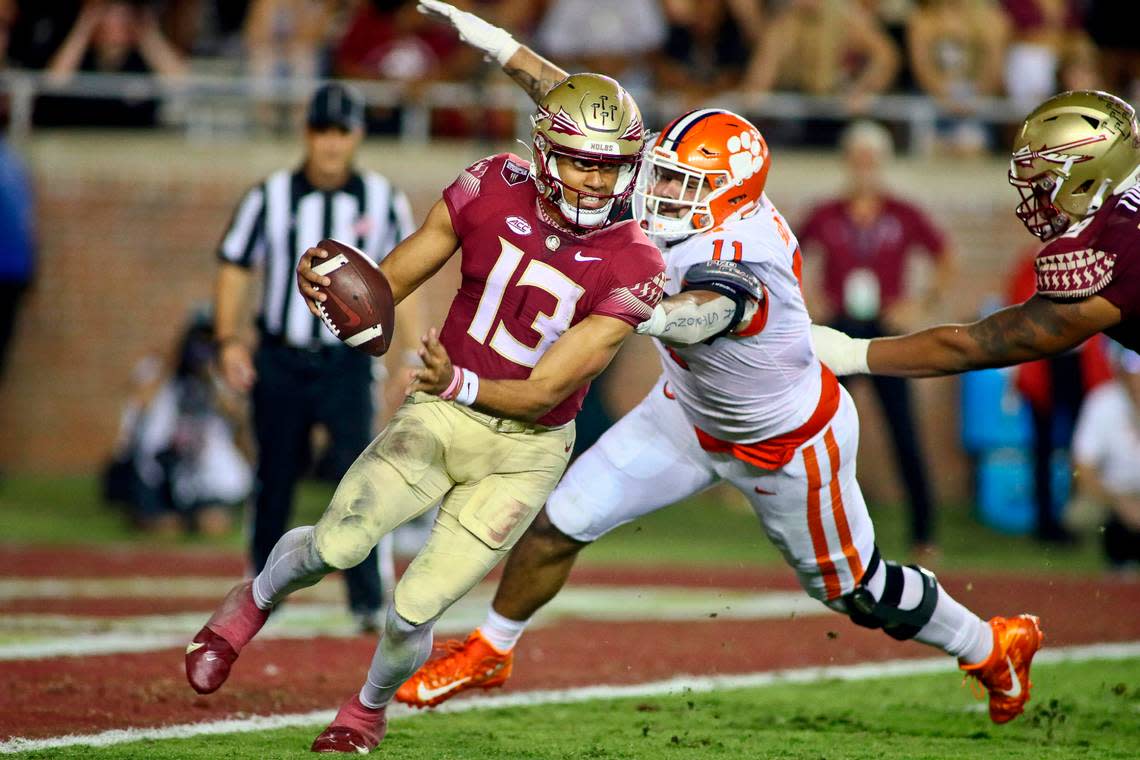 Florida State quarterback Jordan Travis (13) narrowly escapes the grasp of Clemson defensive tackle Bryan Bresee (11) near the goal line during the fourth quarter of an NCAA college football game Saturday, Oct. 15, 2022, in Tallahassee, Fla. Clemson won 34-28. (AP Photo/Phil Sears)