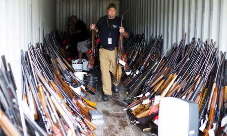 Chesterfield County Sheriff's lieutenant David Lee removes rifles from a shipping container as he and other officers sort through thousands of guns found in the home and garage of Brent Nicholson, in Pageland, South Carolina, November 10, 2015. REUTERS/Jason Miczek