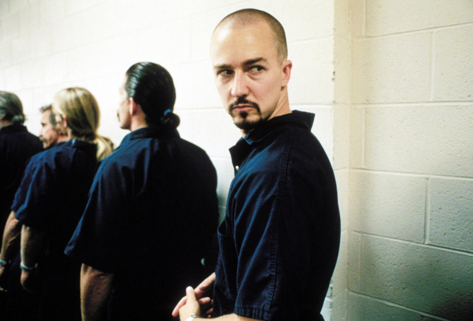 Derek in prison clothes standing in line with other inmates