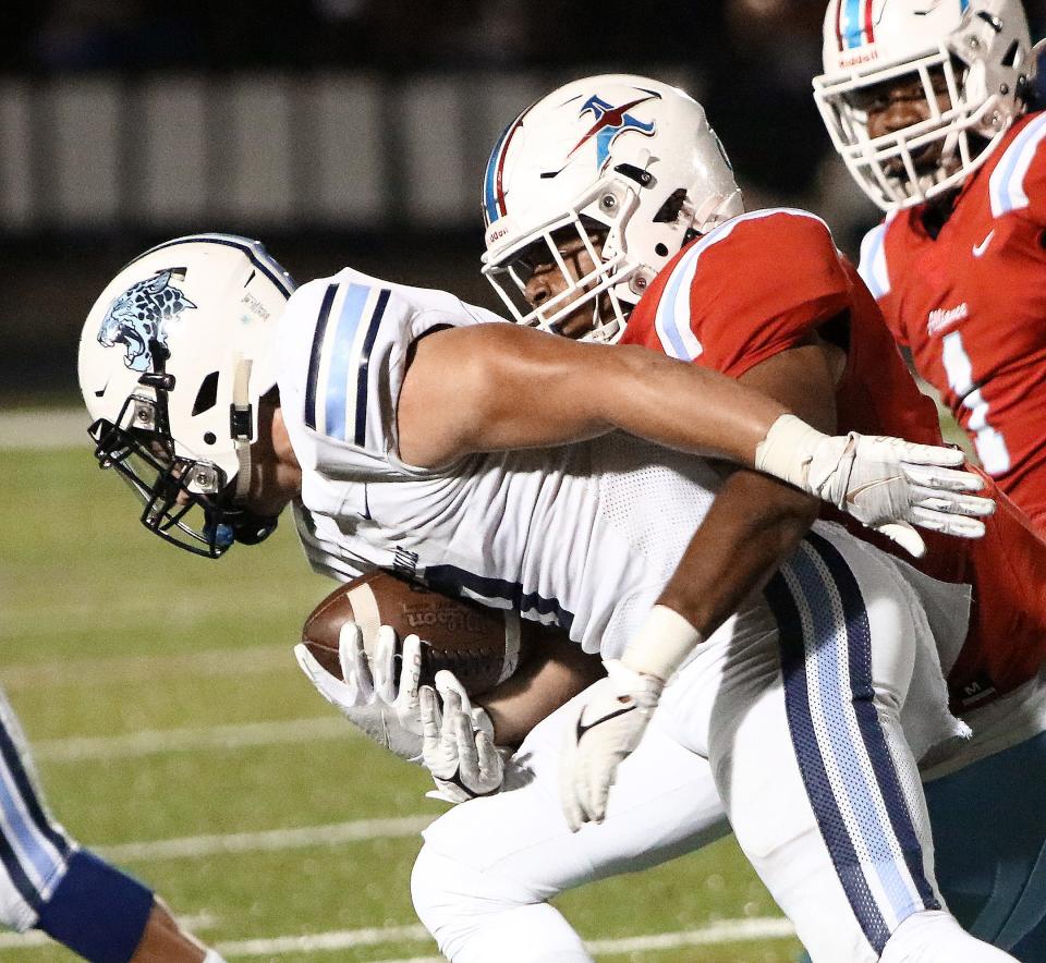 Alliance defender Tyrik Mason, right, wraps up Louisville's Connor Adelman during action Friday, October 15, 2021 at Mount Union Stadium.