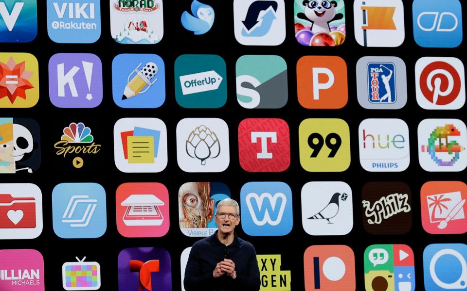 Apple chief executive Tim Cook in front of a screen of apps - AP
