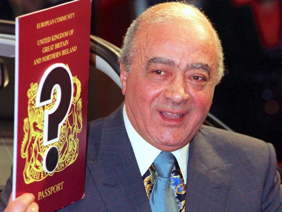 Mohamed Al -Fayed holds up a mock passport in London after his application for a British passport is refused in 1996.