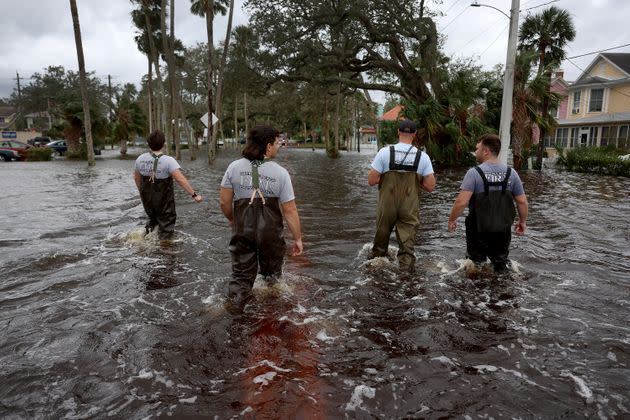 Members of the Daytona Beach Fire Department walk through flood water searching for people that may need help on Thursday in Daytona Beach. (Photo: Joe Raedle via Getty Images)