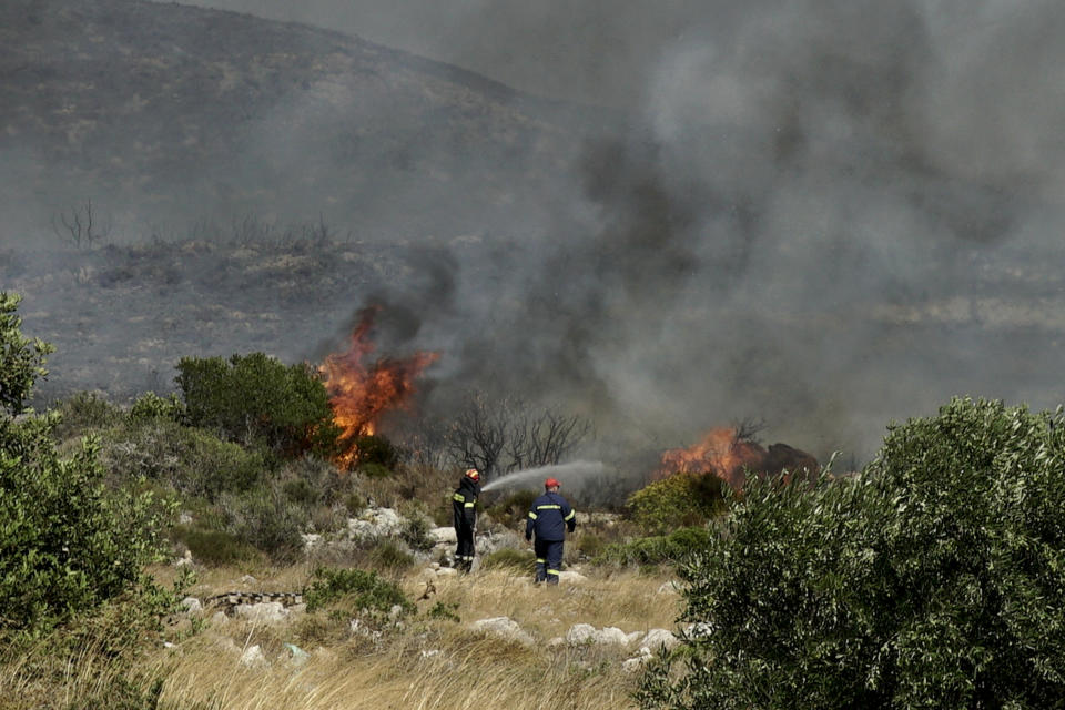 Firefighters extinguish a wildfire at Elafonisos island, south of Peloponnese peninsula, on Saturday, Aug. 10, 2019. A wildfire which broke out on Elafonisos island in southern Greece on Saturday has prompted the evacuation of a hotel and camping as a precautionary measure, with no injuries reported, according to Greek national news agency AMNA. (AP Photo/Nikolia Apostolou)