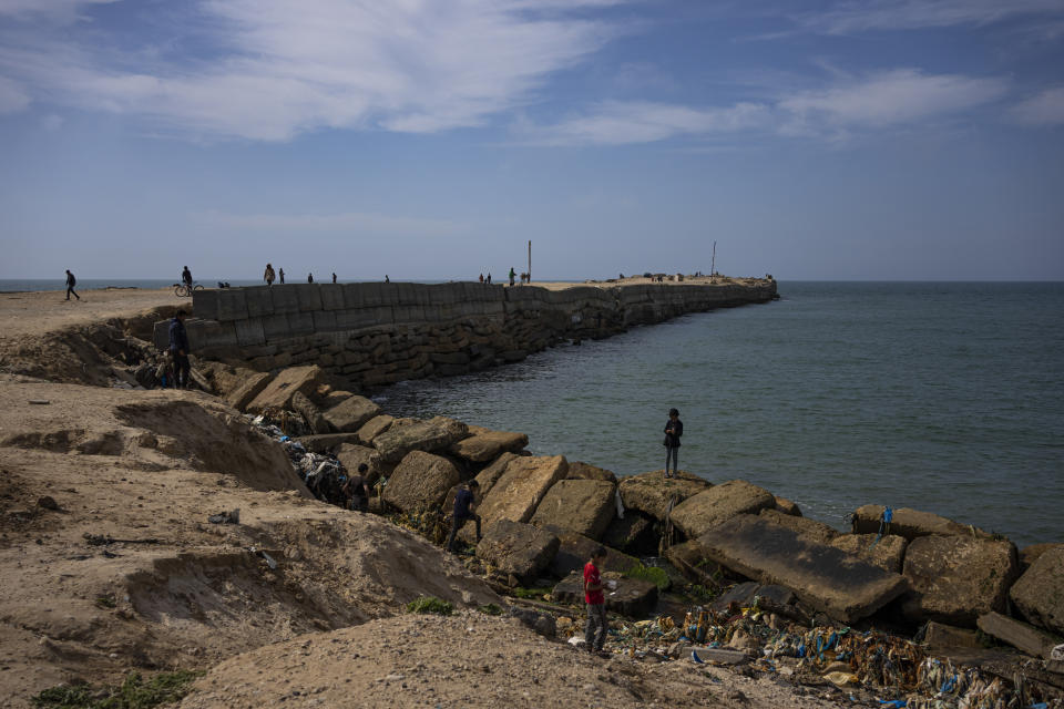 Palestinians walk by a pier that could be used to bring humanitarian aid to the Gaza Strip in Khan Younis on Wednesday, March 13, 2024. (AP Photo/Fatima Shbair)