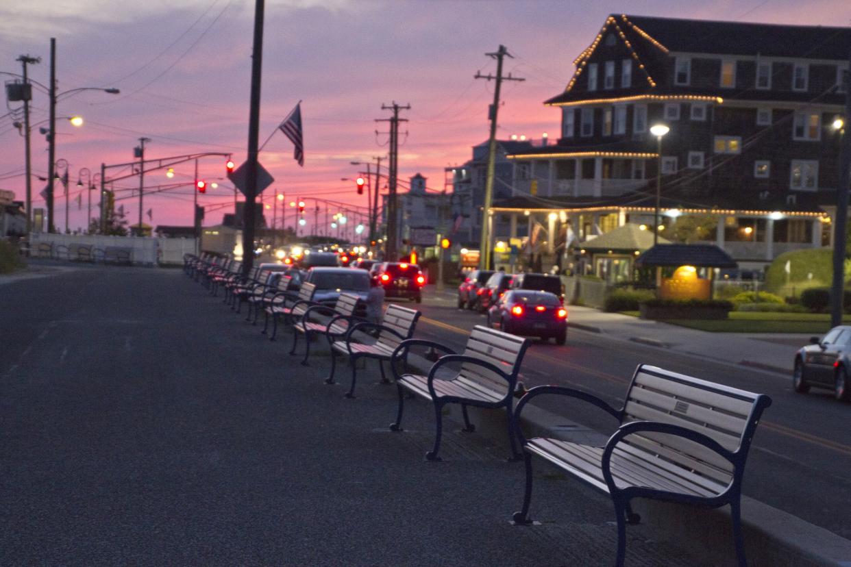 View of the benches along the cement walkway bordering the beach at Cape May, New Jersey at sunset