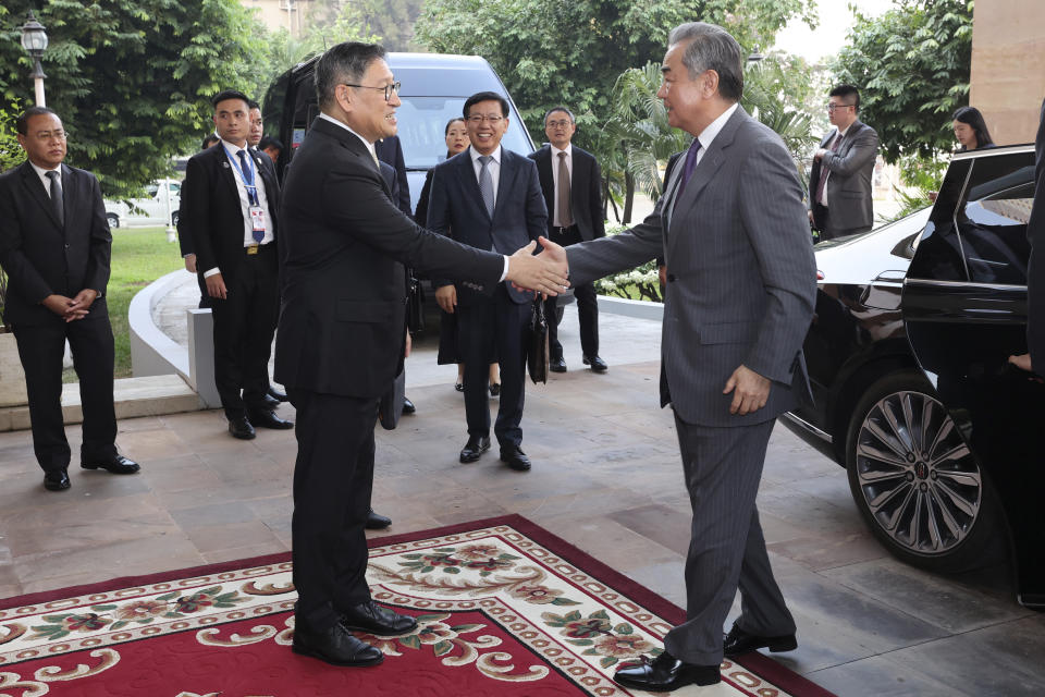 In this photo released by Agence Kampuchea Press (AKP), Chinese Foreign Minister Wang Yi, front right, greets with Cambodia's Foreign Minister, SOK Chenda Sophea, front left, in Phnom Penh, Cambodia, Sunday, April 21, 2024. Wang Yi, arrived Cambodia to mark his 3 days official visit (21-23 April) Cambodia to reaffirm his country's commitment and to boost the already firmly tied to southeast Asian country, twice visited in the last eight months. (AKP via AP)