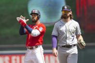Minnesota Twins' Byron Buxton, left, celebrates after hitting a double as Colorado Rockies second baseman Brendan Rodgers (7) looks on in the fourth inning of a baseball game Sunday, June 26, 2022, in Minneapolis. (AP Photo/Andy Clayton-King)