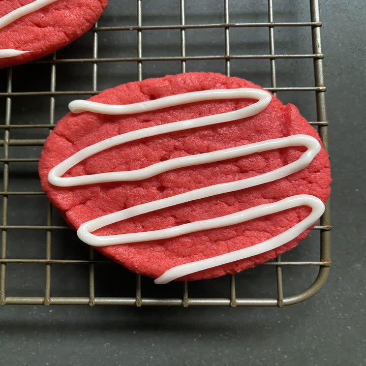 Red cookies with white icing drizzle