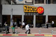 People stand outside a super market in Bnei Brak as Israel enforces a lockdown of the ultra-Orthodox Jewish town badly affected by coronavirus disease (COVID-19), Bnei Brak